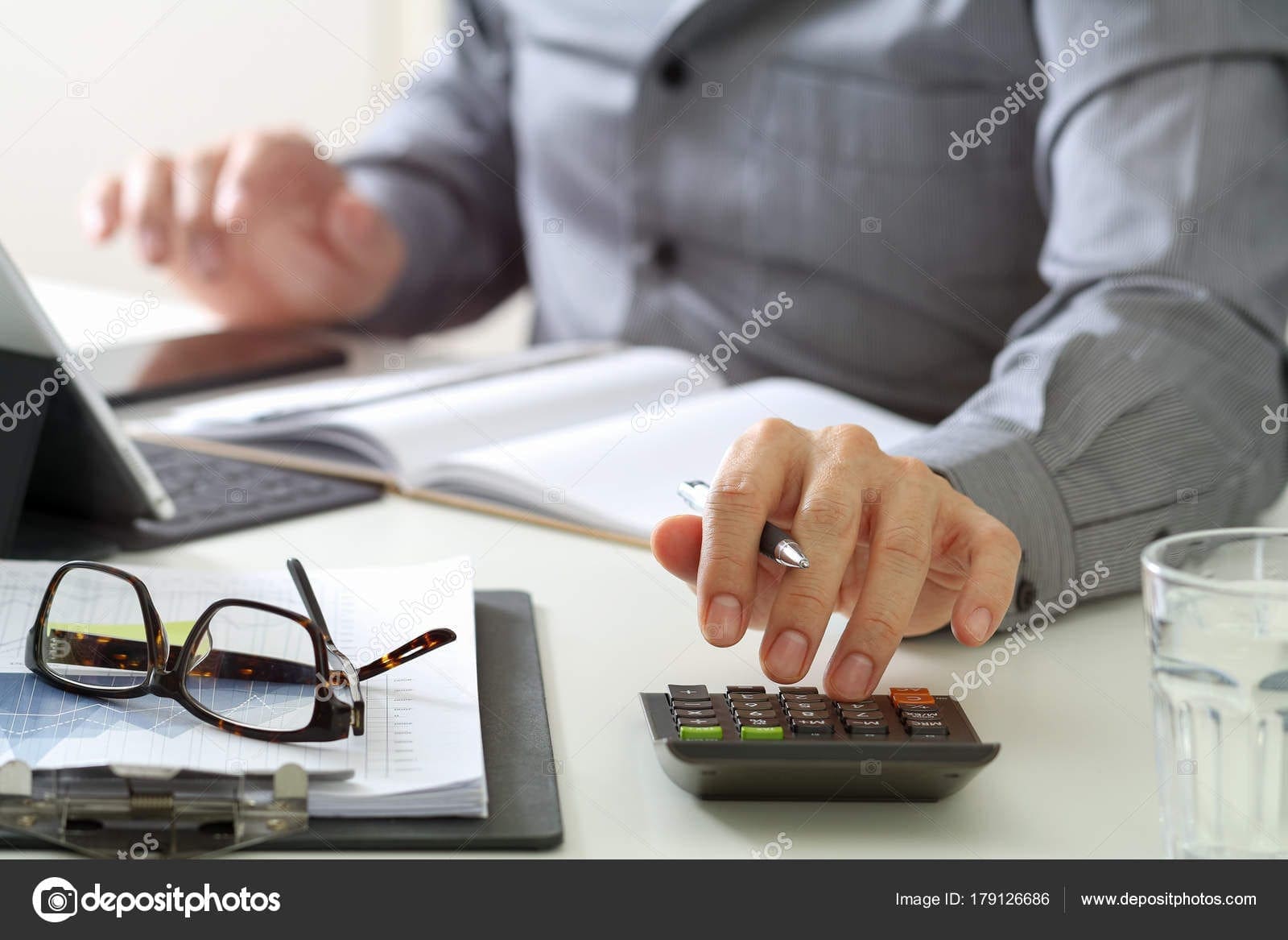 businessman hand working with finances about cost and calculator